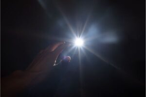 Symbol of hope: Hand seeking light to navigate and overcome negative emotions.